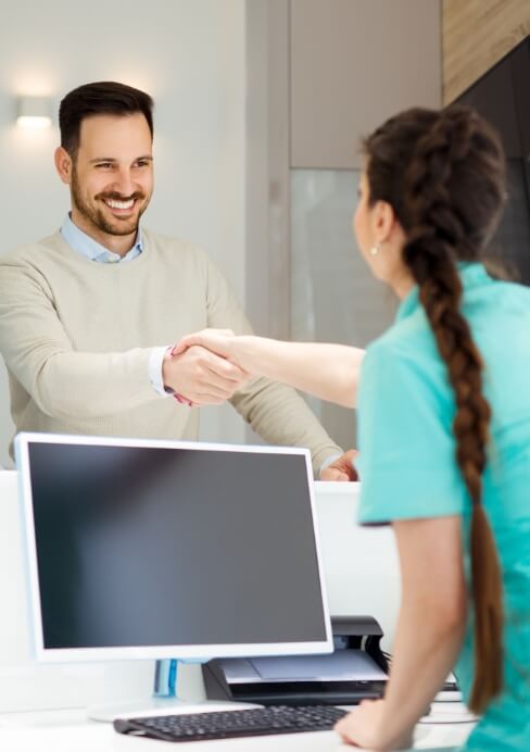 Dental team member greeting dentistry patient