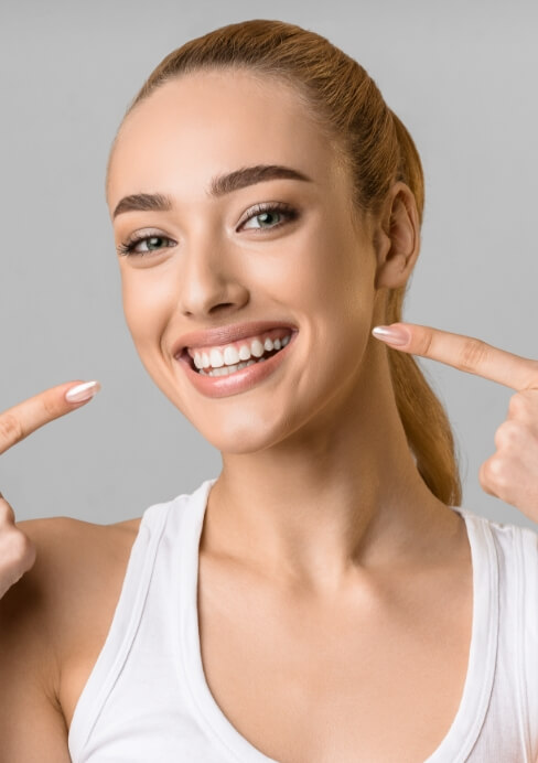 Woman pointing to smile after makeover