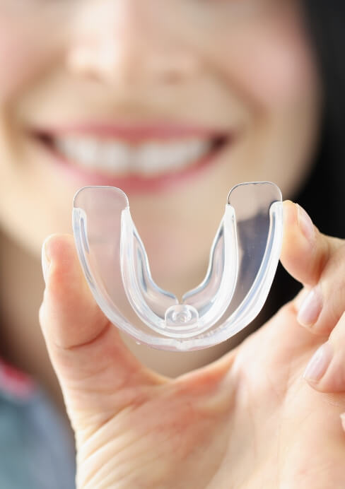 Dental patient holding an athletic mouthguard
