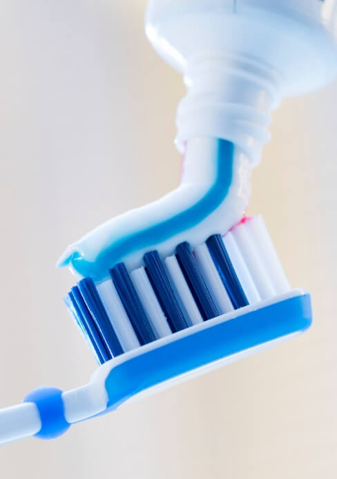 Toothpaste being placed on toothbrush