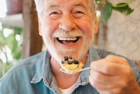 Man smiling while enjoying meal at home