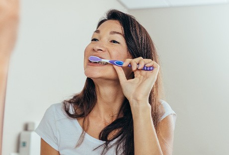 Woman brushing her teeth in bathroom