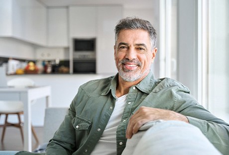 Man smiling while sitting on couch at home