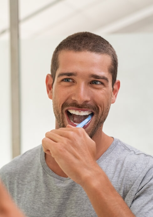 Man brushing teeth to preserve oral health