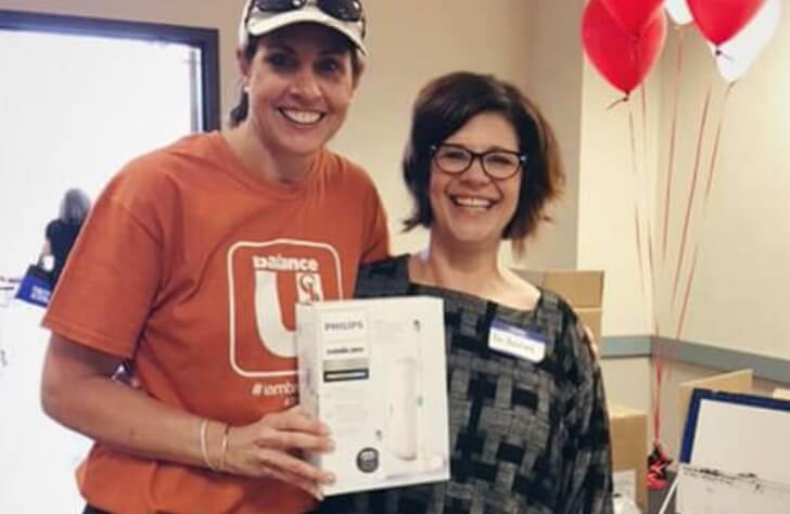 Smiling dental patient receiving a free electric toothbrush