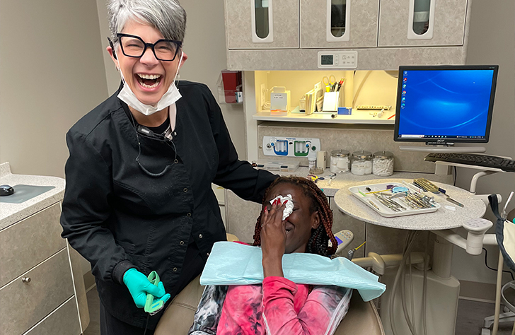 Dentist and dental patient laughing together