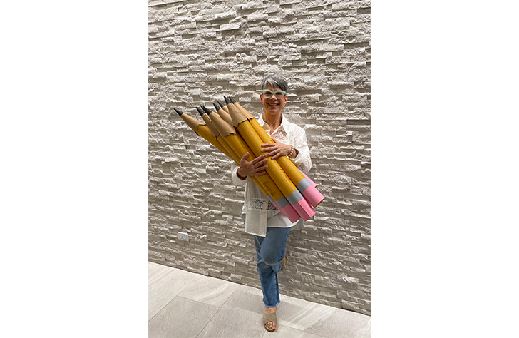 Dentist holding comedically oversized pencils