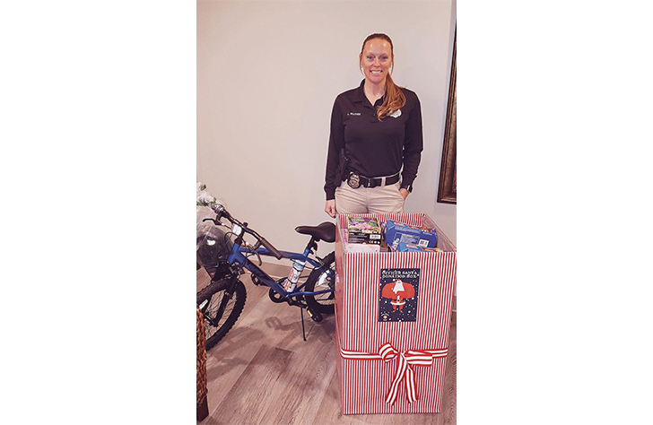 Police officer accepting donated gifts for toy drive