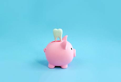 A piggy bank and a decorative tooth against a blue background