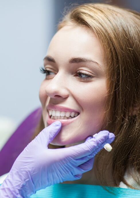 Dentist examining dentistry patient's smile after dental crown restoration