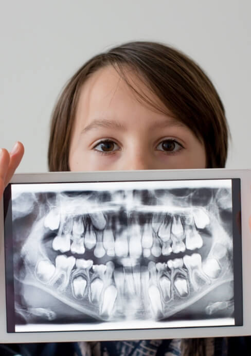 Dental patient holding up tablet computer displaying their digital x rays