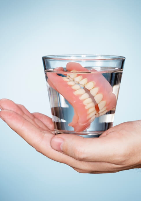 Set of dentures in glass of water