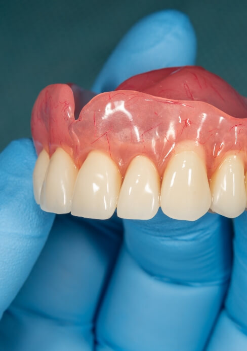 Hand holding a full denture