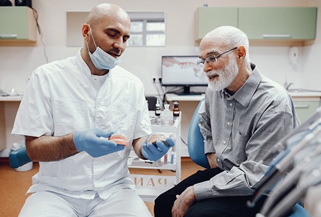 A dentist discussing implant dentures with his patient