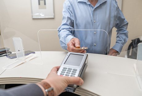 An adult man paying the cost of dentures