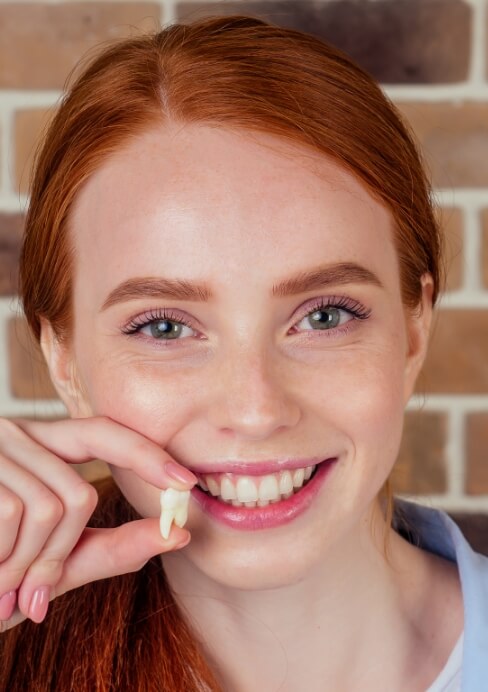 Woman holding tooth after extraction