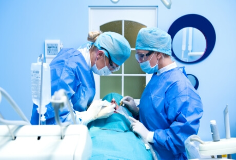 Dentist performing preliminary treatments and dental implant surgery