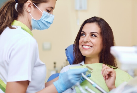 Woman smiling at dentist during initial dental implant consultation