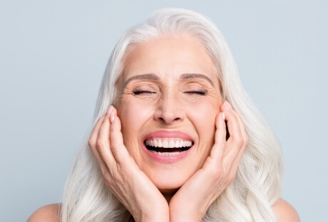 Smiling woman enjoying the day to day benefits of dental implants