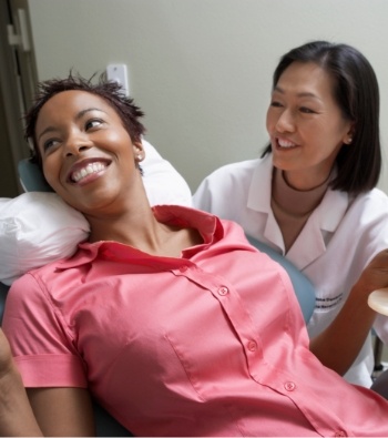 Smiling dental team member and dentistry patient in dental treatment room