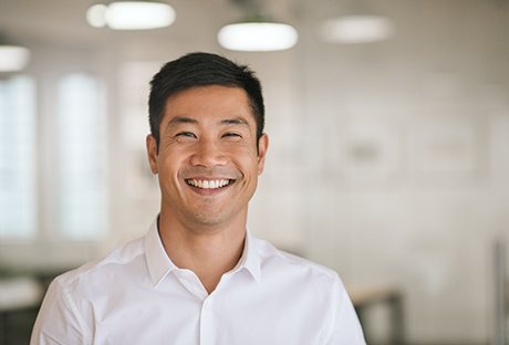 Man in white button-up shirt smiling