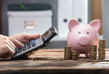 Calculator is used near piggy bank