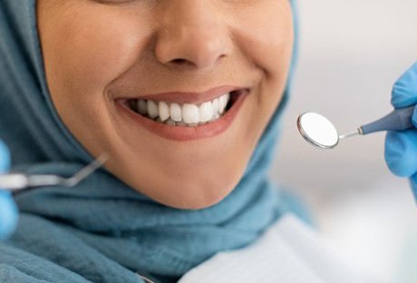 Woman smiling as dentist prepares to examine their straight teeth