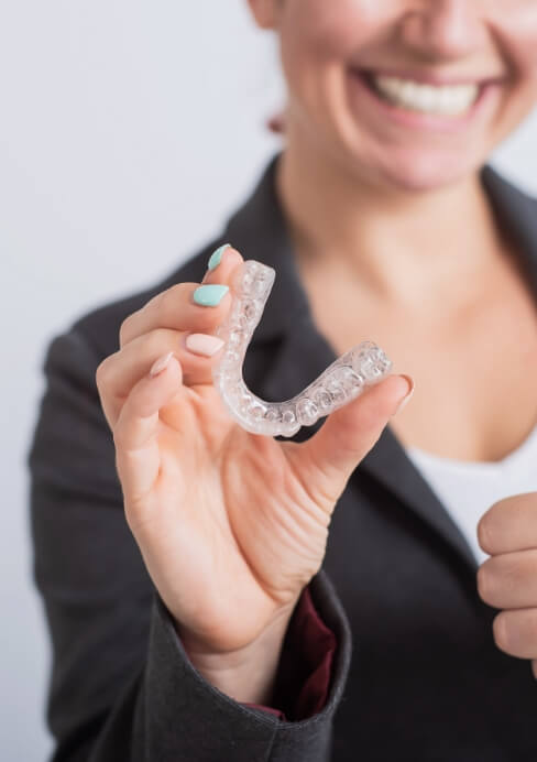 Woman holding an athletic mouthguard