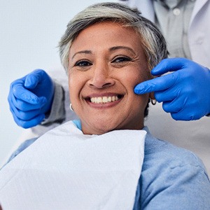 Woman smiling while holding handheld mirror