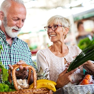 Senior couple smiling while shopping at farmers' market