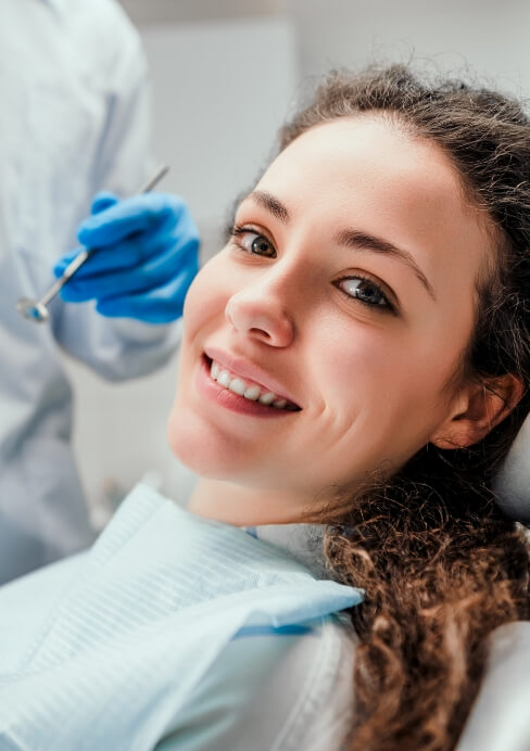 Woman smiling during preventive dentistry checkup and teeth cleaning visit