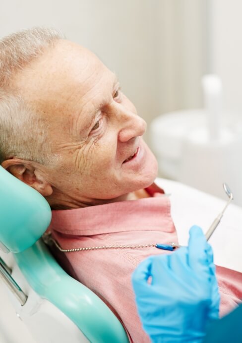 Older man smiling during oral cancer screening