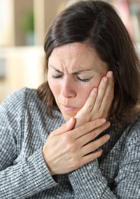 Woman experiencing jaw pain before T M J treatment