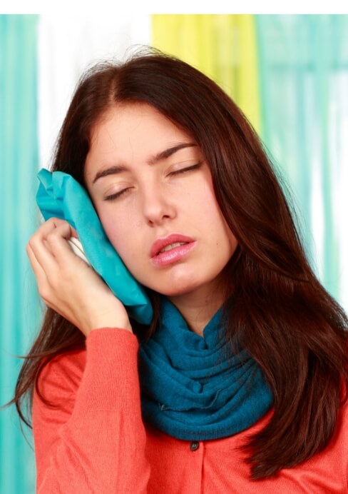 Woman holding ice pack to cheek before T M J treatment