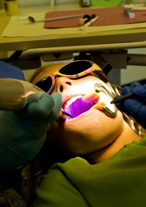 Dentist performing VELScope oral cancer screening