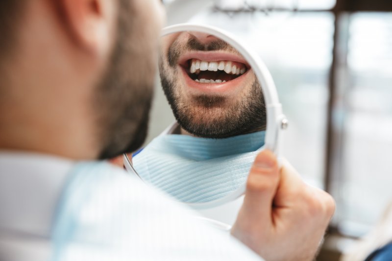 Man smiling at his new porcelain veneers