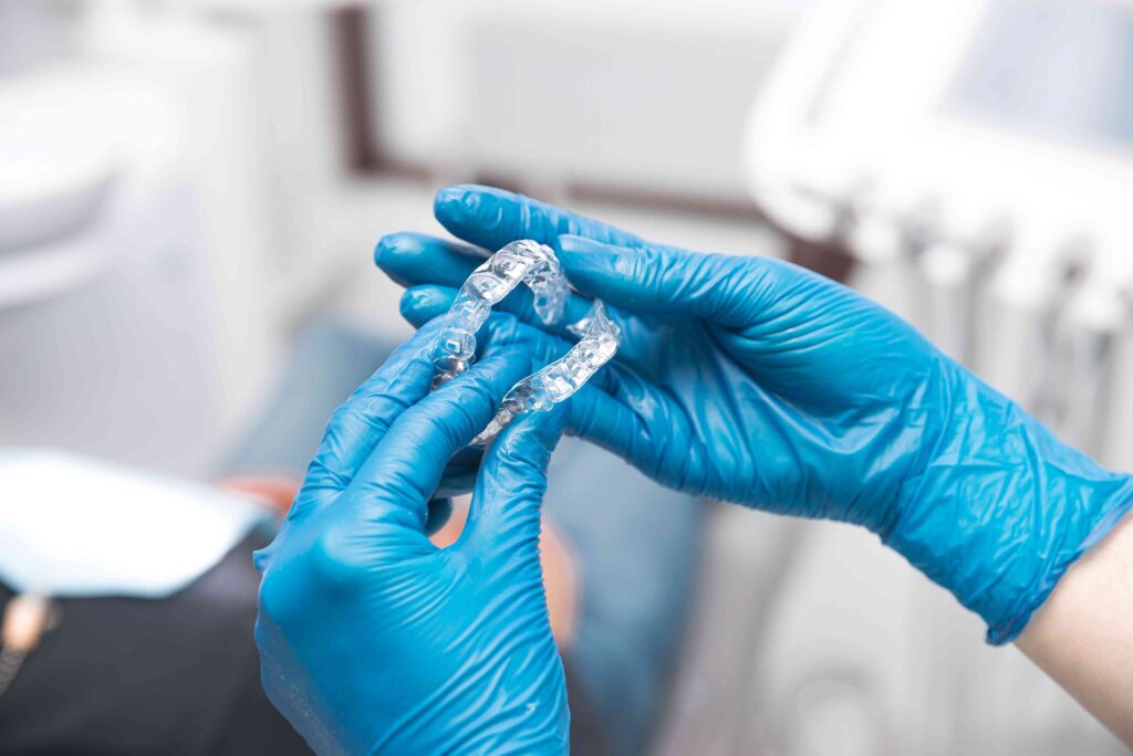 Dentist holding clear aligners