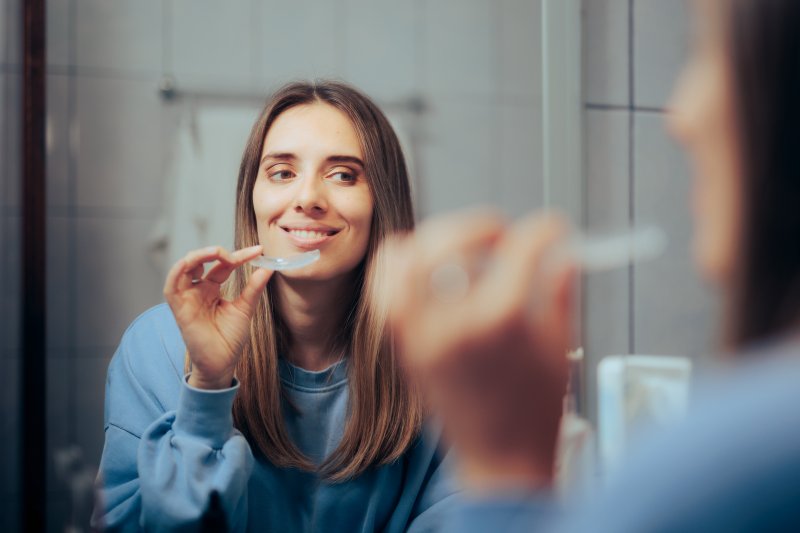 Invisalign patient smiling in the mirror