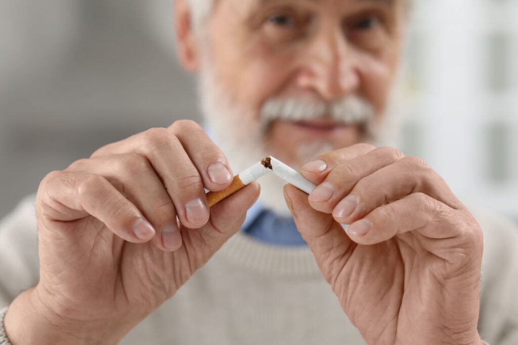 A man breaking a cigarette in half